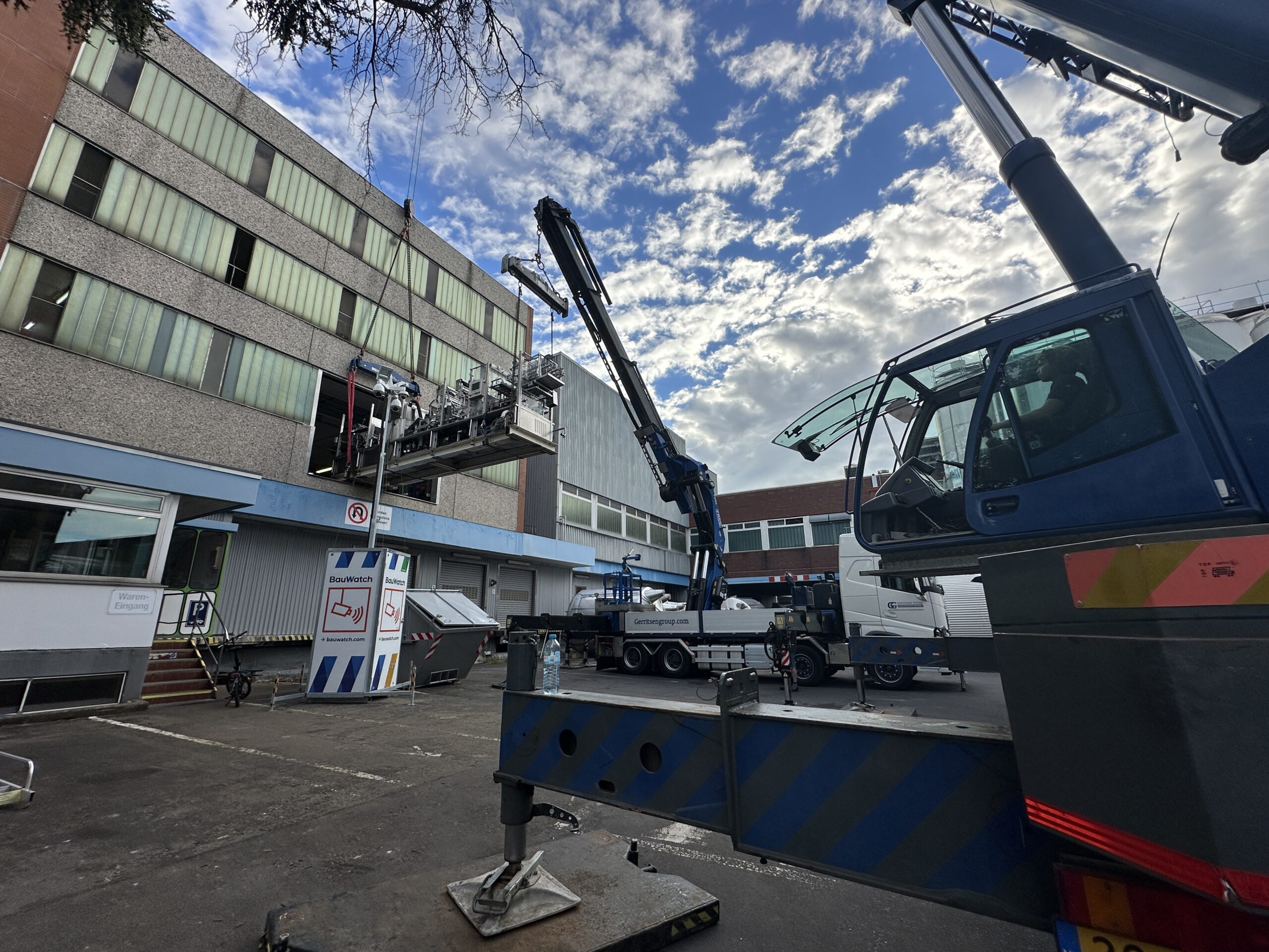 Lifting a machine out of a building with a truck mounted crane and crane.